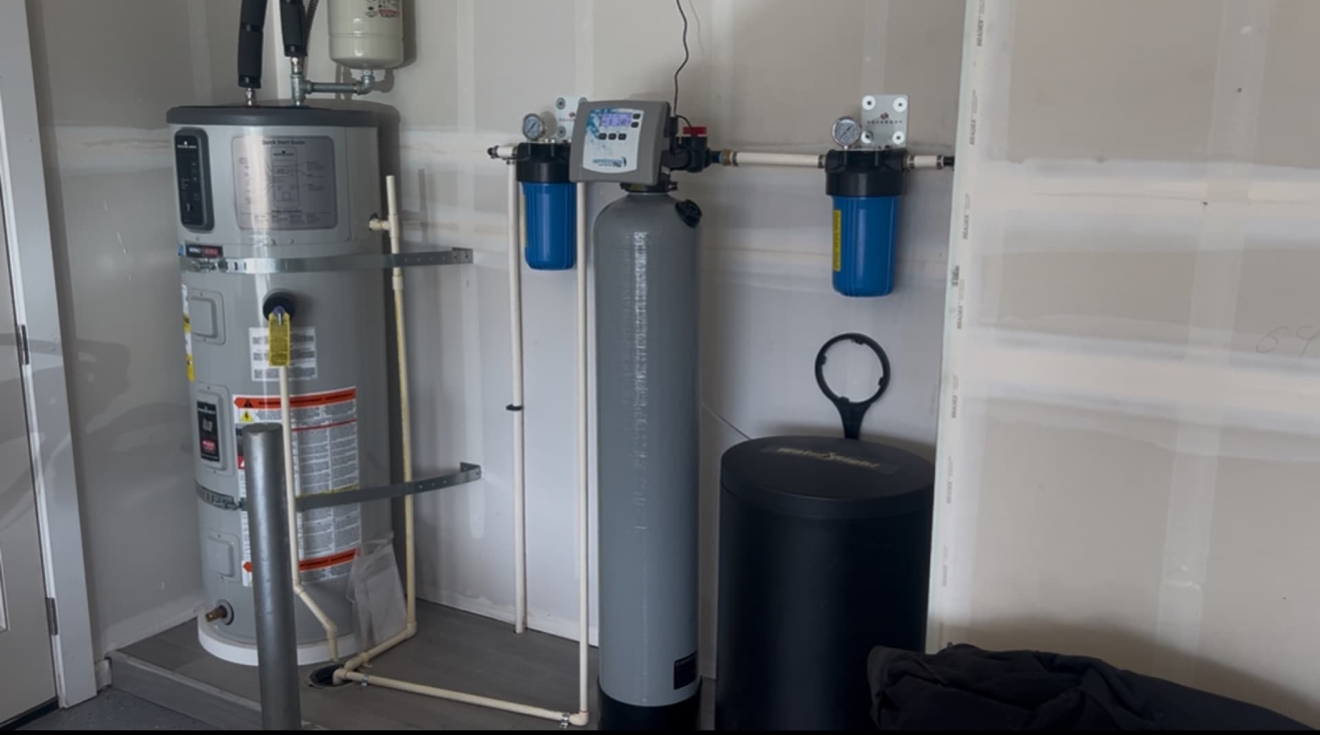 Technician finishing a whole-home filtration install in a Torrance garage