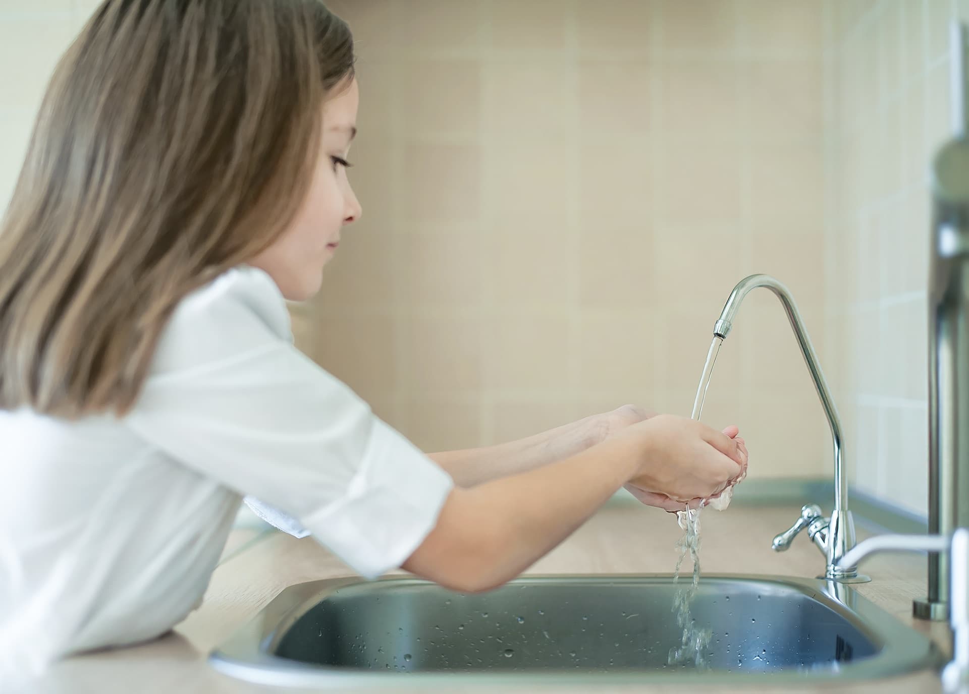 Child washing hands with clean filtered water
